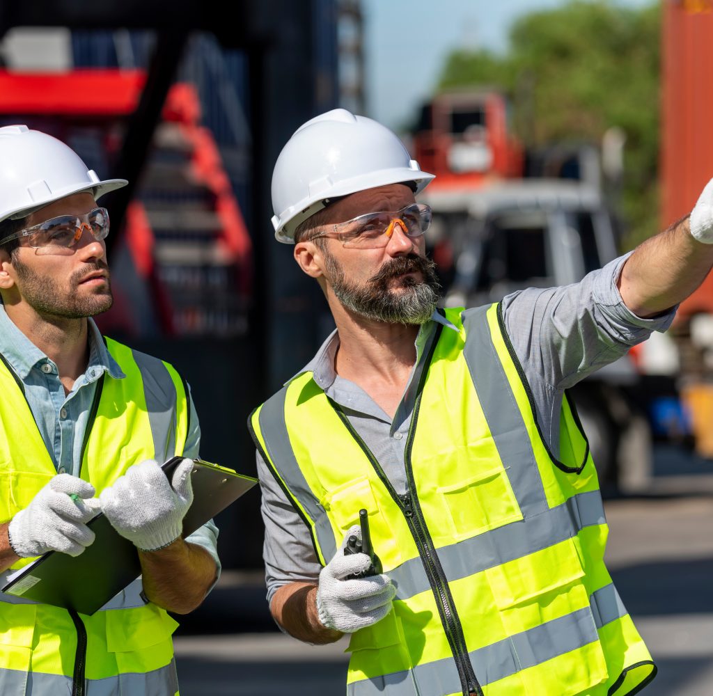 Logistics engineer and inspector working togetter and discussing in shipping containerin commercial transport port